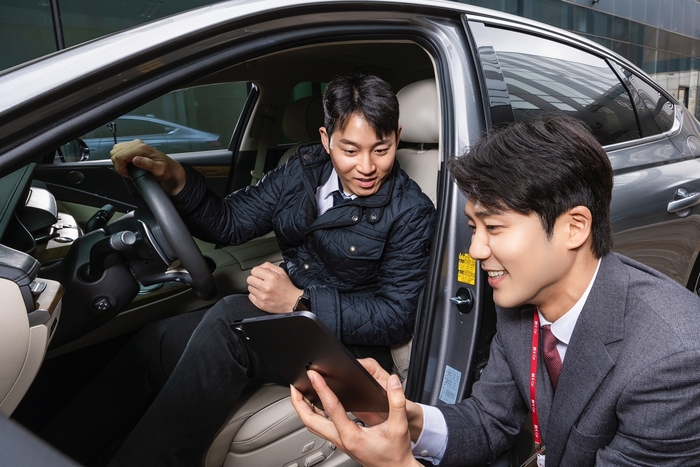 중고차 플랫폼 직원이 고객에게 차량을 설명하고 있다.